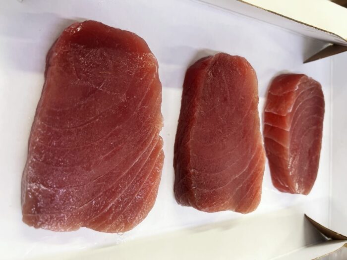 Three tuna steaks neatly arranged in a box