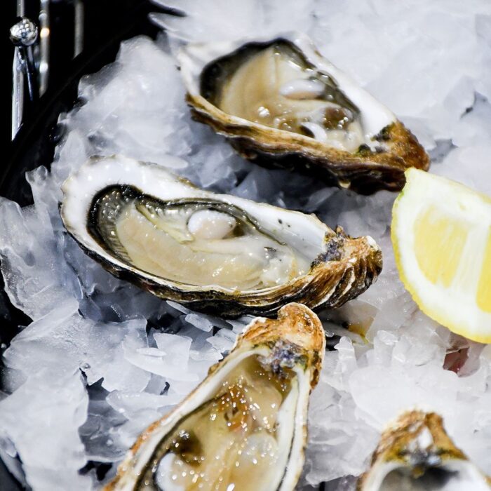 Prepared, shucked and open oysters served on a bed of ice with a lemon wedge.